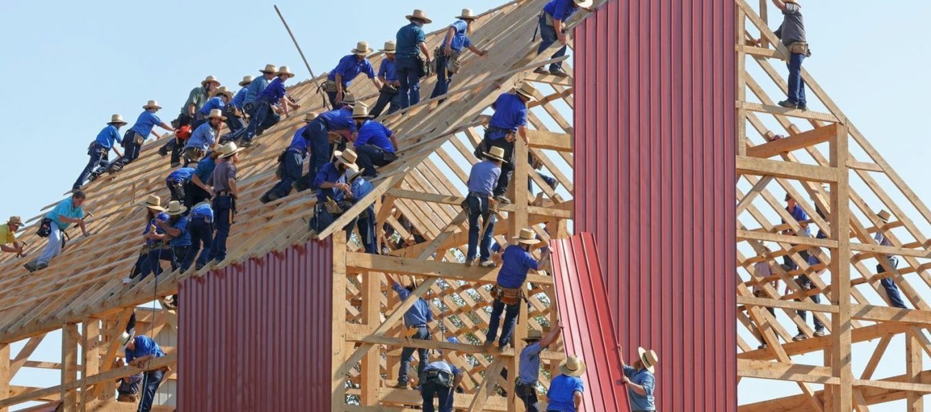 image of a barn with many Amish men in various positions building