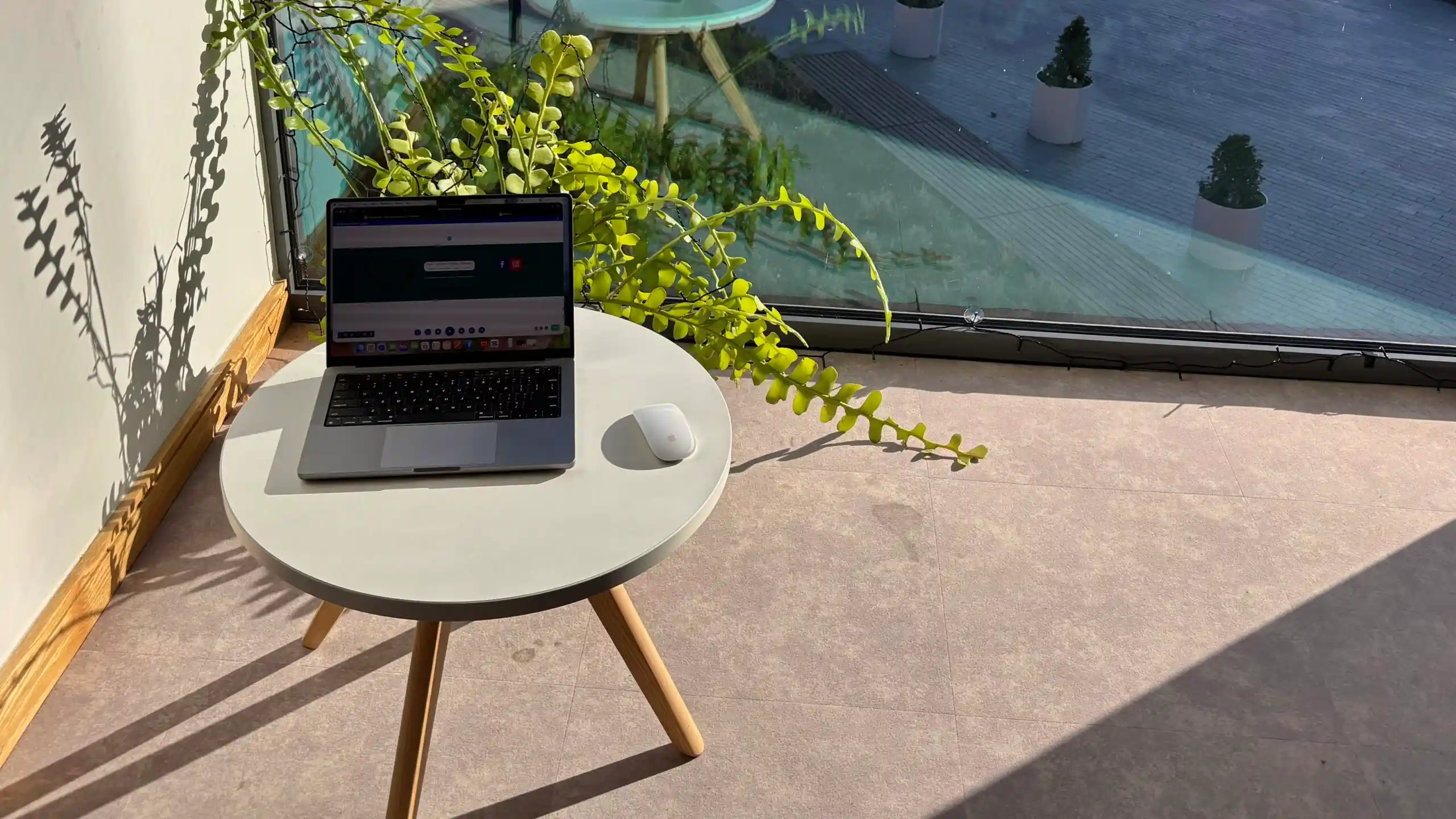 Sunlight across a work desk with a laptop and notebook, creating a bright and focused workspace.
