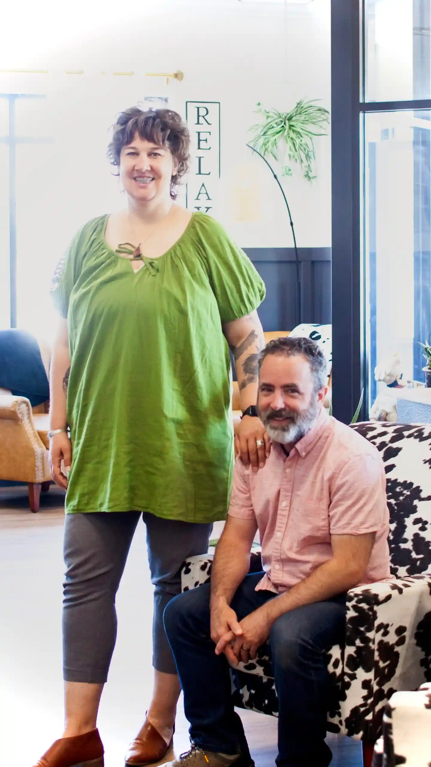 Lisa is standing next to Chad who is seated