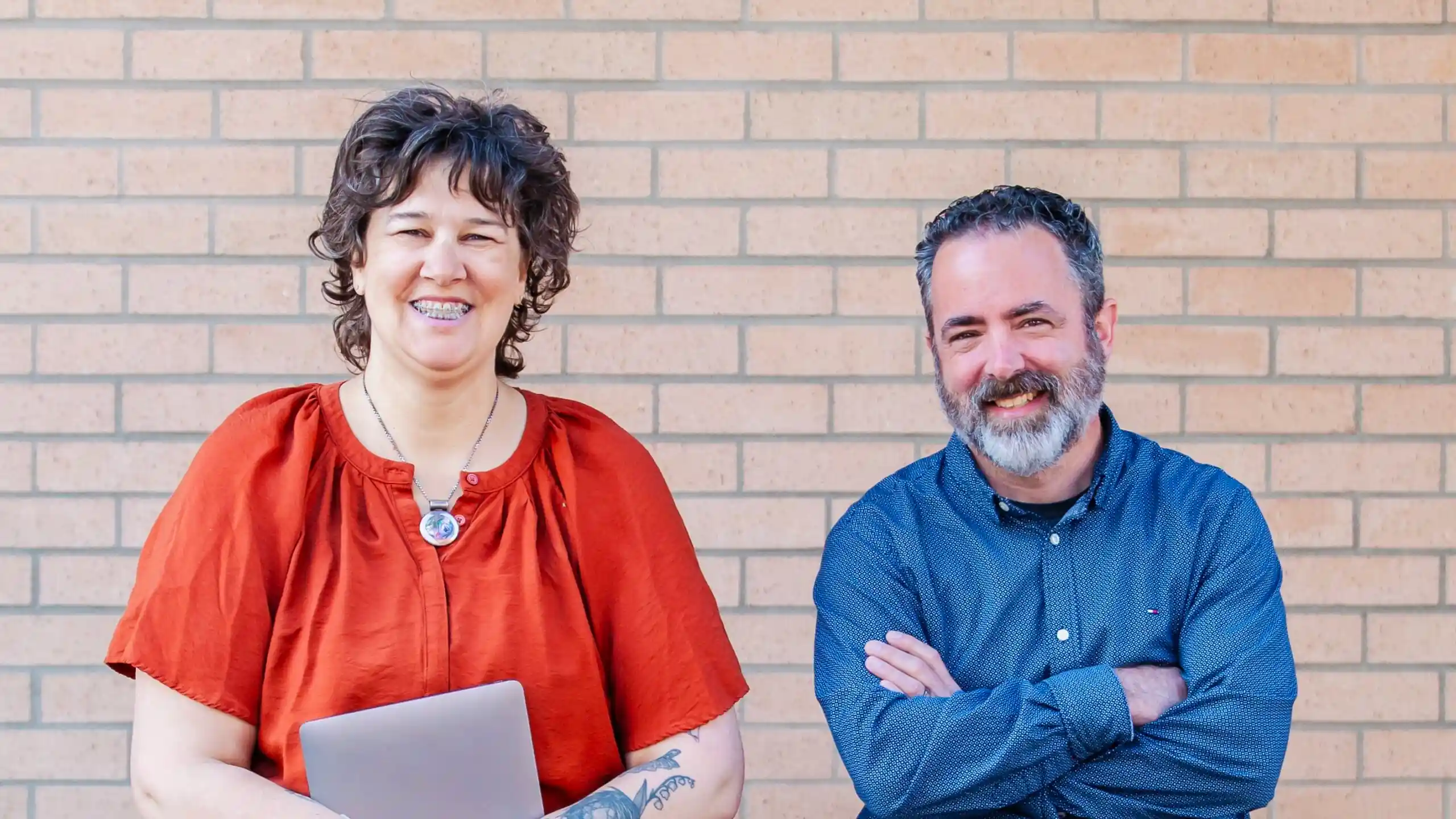 a woman (Lisa) and a man (Chad) posed in front of a brick wall
